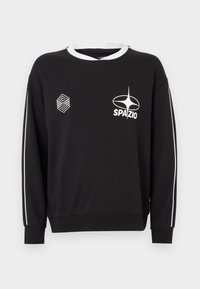 Fekete pulóver fehér díszítéssel, kerek nyakkal, hosszú ujjakkal és két logóval elöl. Puha, texturált anyag.