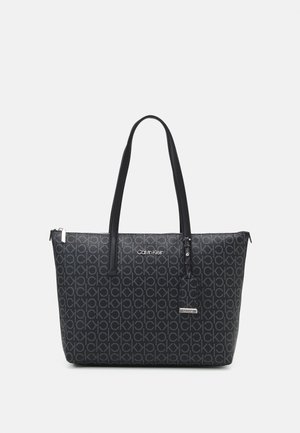 Sac cabas noir Calvin Klein avec motif logo CK répétitif, doubles anses d’épaule et petite étiquette suspendue avec le nom de la marque.
