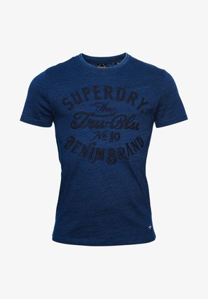 Laivastonsininen, lyhythihainen t-paita pyöreällä pääntiellä ja mustalla kirjotulla tekstillä "Superdry The Tru Blu No 10 Denim Brand" edessä.