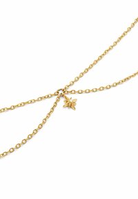 Collana in oro con un piccolo pendente a forma di foglia adornato con una pietra scintillante. La catena presenta maglie di dimensioni uniformi e una finitura elegante.