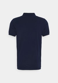Polo bleu marine à manches courtes avec col et poignets côtelés, vu de dos sur un fond blanc uni.