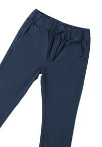 Granatowe spodnie dresowe mają elastyczny pas ze sznurkiem, boczne kieszenie oraz miękką, gładką teksturę materiału.