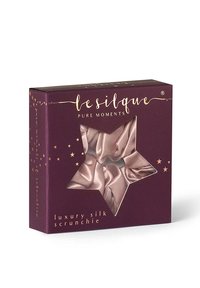 Luxe zijden scrunchie in zachtroze, verpakt in een paarse doos met stervormig venster, met gouden tekst en decoratieve steraccenten.