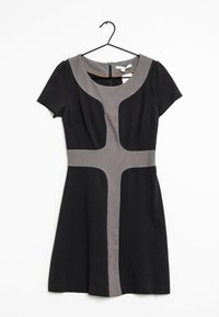 Svart kortärmad klänning med grått korsdesign på framsidan, rund halsringning och dragkedja bak, hängande på svart galje mot vit bakgrund.