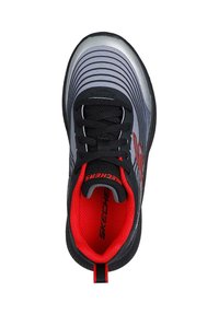 Zapato deportivo negro y gris con parte superior texturizada, acentos rojos e interior acolchado, con cordones negros y detalle de logo en el lateral.