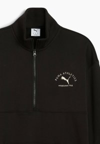Felpa nera con colletto alto, mezza zip e logo frontale in testo bianco e silhouette. Texture morbida, design sportivo, vestibilità casual.