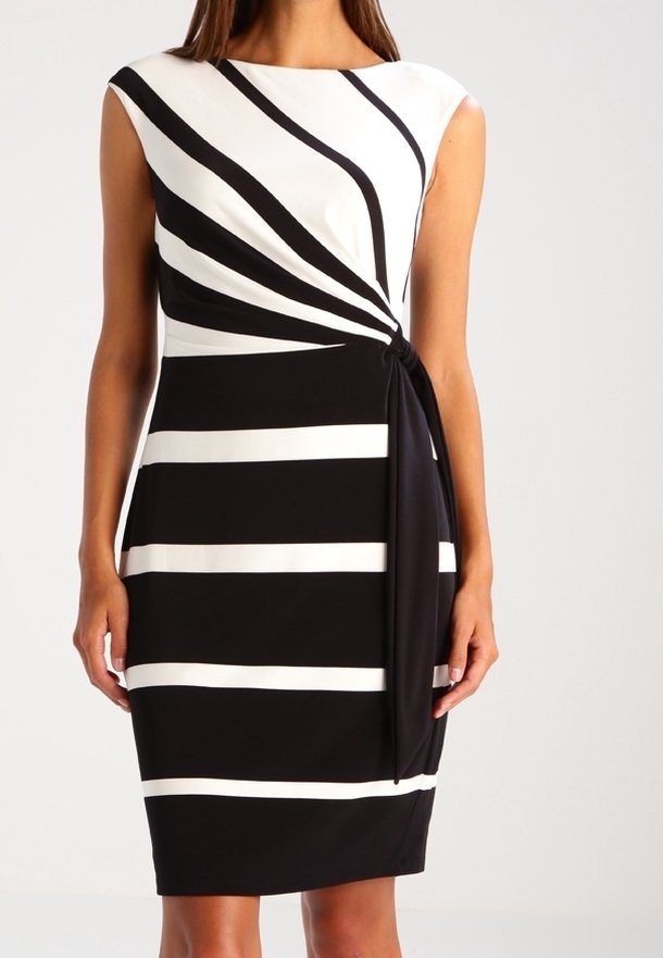 Abito a righe bianche e nere con un design frontale attorcigliato, corpetto superiore in tinta unita, maniche corte e gonna di lunghezza al ginocchio. Tessuto dalla trama liscia.