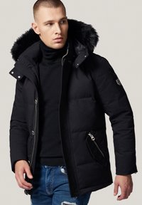 Czarna kurtka puchowa z kapturem wyściełanym futrem, kieszeniami na zamek błyskawiczny i dopasowanym krojem. Wykonana z materiału izolacyjnego dla zapewnienia ciepła.