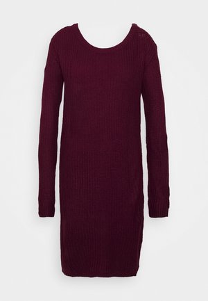 Robe tricotée à manches longues, longueur genoux, bordeaux foncé avec un col rond sur fond blanc.