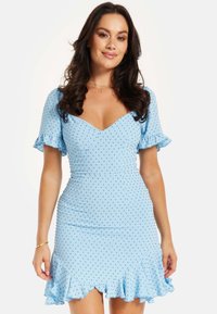 Light blue dress with short ruffled sleeves and a fitted bodice. Features small black polka dots and a ruffled hemline with a V-neck design.