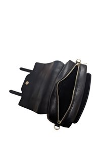 Borsa nera in pelle con chiusura a zip, design piatto e texture liscia. Presenta un bottone a scatto e due manici corti per un trasporto comodo.