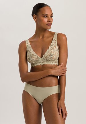 Bralette en dentelle beige clair avec un décolleté en V profond, motif floral et larges bretelles, associé à un slip bikini sans coutures dans une teinte unie.