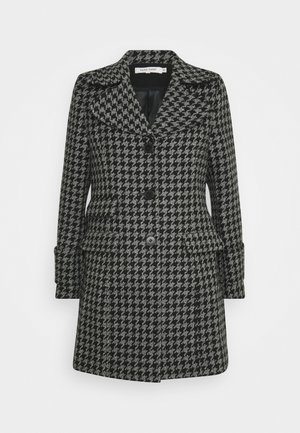 Cappotto con motivo pied de poule in bianco e nero, con rever a lancia, bottoni frontali e tasche laterali. Taglio sartoriale con maniche lunghe.