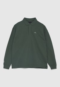 Polo à manches longues vert foncé avec un petit logo blanc sur le côté gauche de la poitrine et des poignets côtelés, présenté à plat sur un fond clair.