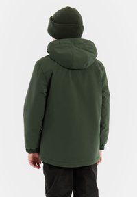 Grüne wasserdichte Jacke mit Kapuze, elastischen Bündchen und Kordelzugsaum, kombiniert mit einer passenden Mütze. Glatte Textur, praktisches Design.