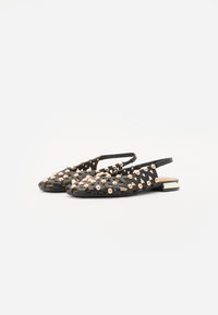Scarpe flat nere intrecciate con punta e tallone scoperti, decorate con borchie metalliche color oro rosa e un basso accento rettangolare argentato sul tallone.