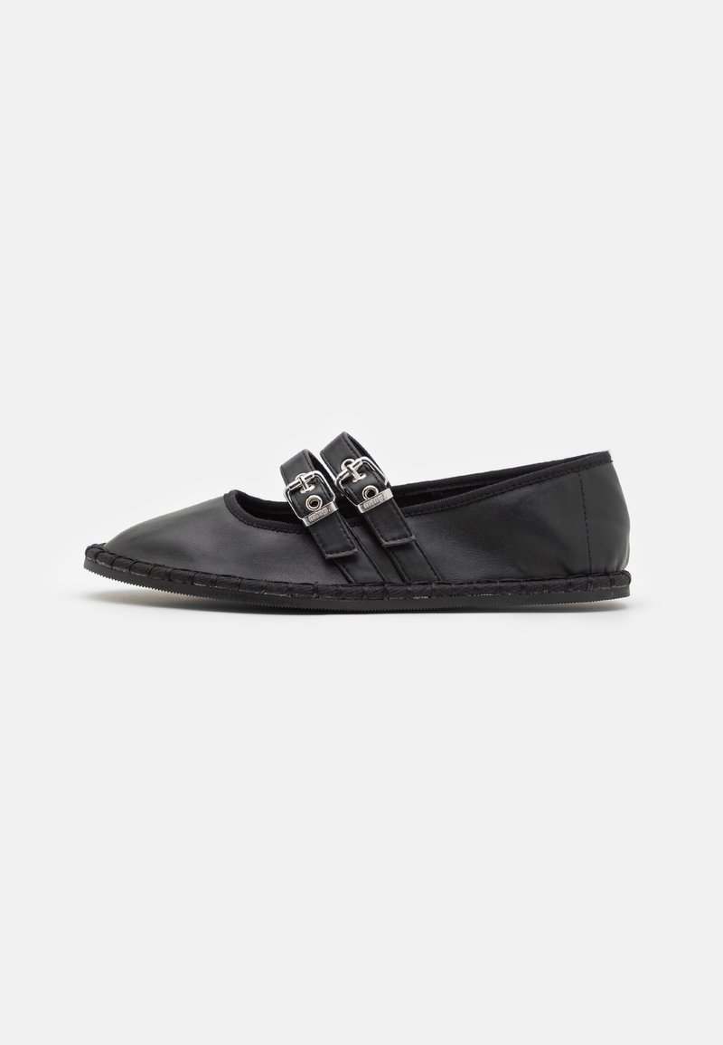 Chaussure plate en cuir noir avec deux brides ajustables à boucle argentée et semelle cousue, vue de profil sur fond uni.