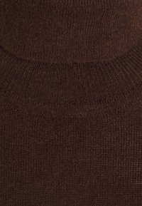 Dunkelbrauner gestrickter Rollkragenpullover aus weichem Stoff mit gerippter Textur und einem enganliegenden Kragendesign.