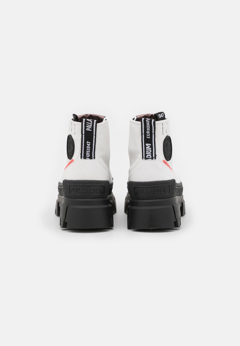 Bottines blanches à cheville avec un design montante, semelle noire contrastante, accents de marque noirs et finition texturée sur le matériau supérieur.