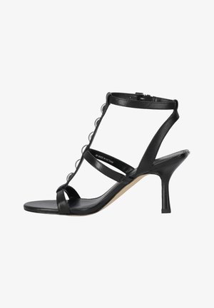 Sandale à talons hauts en cuir noir avec bride à la cheville, bride en T ornée de petits anneaux argentés et talon aiguille fin.