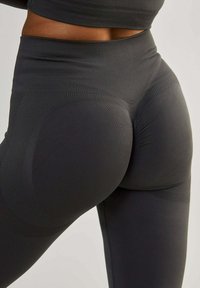 Hochtaillierte, schwarze Leggings aus dehnbarem Stoff. Enthält strukturierte Einsätze und Kontournähte für verbesserten Sitz und Unterstützung.