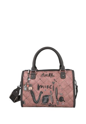 Bolso de mano acolchado rosa con acentos negros, que presenta texto decorativo, lentejuelas y una correa desmontable. El hardware incluye adornos de metal.