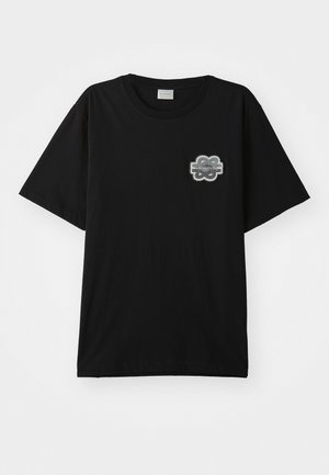 T-shirt noir en coton avec un col rond et des manches courtes. Présente un patch floral gris sur la poitrine gauche. Design simple et sans embellissements.