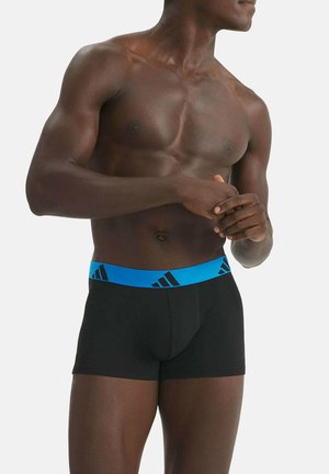 Schwarze Boxershorts mit einem hellblauen Bund, der das Adidas-Logo zeigt. Der Stoff wirkt glatt und eng anliegend.