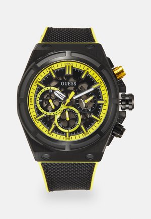 Schwarze Chronographuhr mit gelben Akzenten, strukturierter schwarzer Armband und auffälligen Ziffern. Verfügt über ein Skelettzifferblatt und auffällige Zahlenmarkierungen.