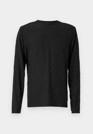 Long-sleeve black t-shirt featuring a textured pattern with a subtle design, crew neckline, and straight cut hem. Soft fabric texture.