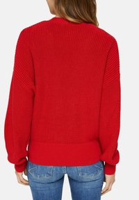 Roter Strickpullover mit gerippter Textur, Rundhalsausschnitt und Ballonärmeln, am Taillen- und Handgelenkabschluss.