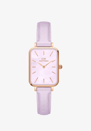 Kvadraten ura z rožnato zlato kovinsko ohišje in vijoličastim usnjenim trakcem. Ima svetlo vijolično številčnico z zlatimi oznakami in kazalci.