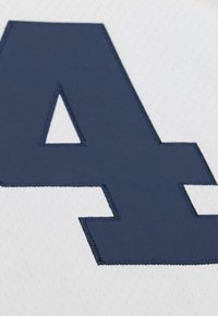 Close-up of a large navy blue number 4 stitched onto white breathable fabric, likely part of a sports jersey.