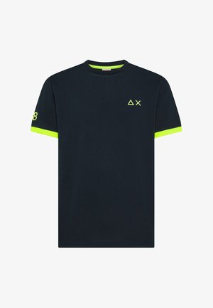 Maglietta nera a maniche corte con polsini delle maniche giallo neon, piccoli simboli a triangolo e a X sul petto, e numero 8 sulla manica sinistra.