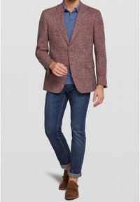 Blazer marrone a fantasia sopra una camicia blu, abbinato a jeans scuri e scarpe marroni. Il blazer presenta una chiusura a due bottoni e tasche.