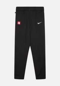 Melni sporta bikses, kas izgatavotas no mīksta auduma, ar sarkanu un baltu pārbaudītu logo uzlišanu un baltu Nike simbolu. Elastīga josta.