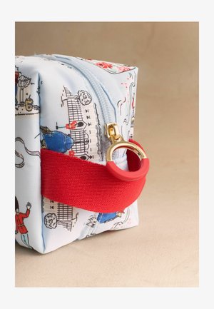 Mała materiałowa saszetka z motywami londyńskimi, niebieskim zamkiem błyskawicznym, złotym suwakem i czerwonym materiałowym uchwytem.