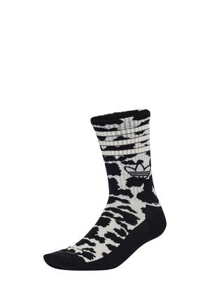 Sort-hvid crew sok med zebra mønster og tre hvide vandrette striber nær toppen, med trefoil-logo på siden.