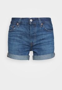 Shorts en denim bleu foncé avec un ourlet effiloché et des poignets roulés. Comprend cinq poches et une fermeture à bouton avec des accents en métal cuivré.