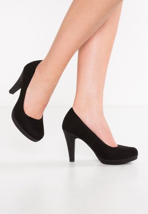 Zapatos de salón de ante negro con tacón alto, punta redonda, textura suave, tacón elevado, diseño sin costuras, ligero con un brillo sutil en la suela.