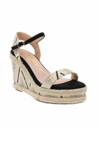 Sandalo con zeppa caratterizzato da una parte superiore in tessuto intrecciato a motivo in crema e nero, cinturini in suede neri e una piattaforma avvolta in juta.