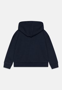 Námořnická modrá mikina s kapucí, vyrobená z měkkého materiálu, s dlouhými rukávy, volným střihem a žebrovanými lemy a manžetami.