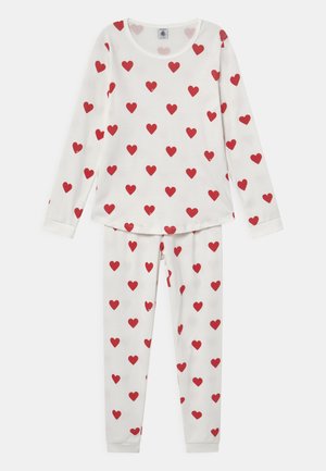 Witte pyjama set met lange mouwen en broek, met een herhaald patroon van kleine rode hartjes op zachte stof. Ronde halslijn, aansluitende boorden.