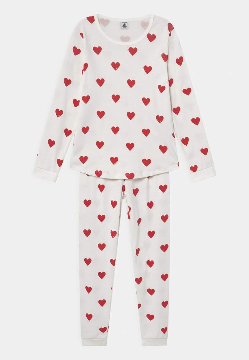 White pajama set with long sleeves and pants, featuring a repeated pattern of small red hearts on soft fabric. Round neckline, fitted cuffs.