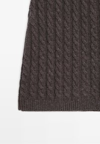 Tissu tricoté gris foncé avec un motif torsadé et une bordure côtelée, probablement une partie d’un pull ou d’une écharpe, sur fond blanc.