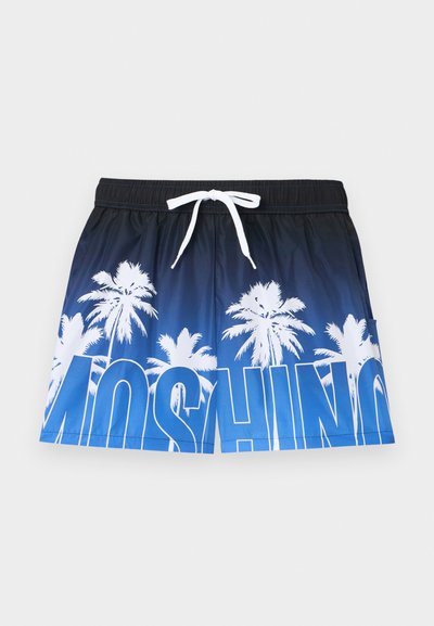 Shorts de bain bleu et noir avec des silhouettes de palmiers blanches et un grand texte blanc et bleu en bas, dotés d'une ceinture à cordon de serrage blanche.