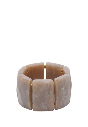 Bracelet extensible composé de grands segments rectangulaires en résine beige marbrée, reliés par des maillons élastiques dorés.