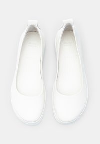 Ballerine in pelle bianca con punta arrotondata, design minimalista, piccolo tacco posteriore e texture liscia. L'interno è leggermente testurizzato.