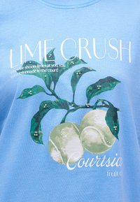 Μπλε πουκάμισο με πράσινο κλαδί λάιμ και μπάλες τένις, λευκό κείμενο που λέει "LIME CRUSH" και "Όταν η ζωή σου πετά λάιμ, φέρε λεμονάδα στο γήπεδο!"