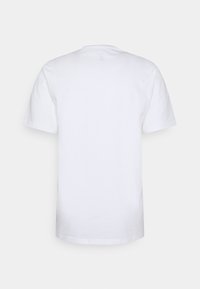 Camiseta blanca de mangas cortas mostrada desde atrás sobre un fondo blanco.